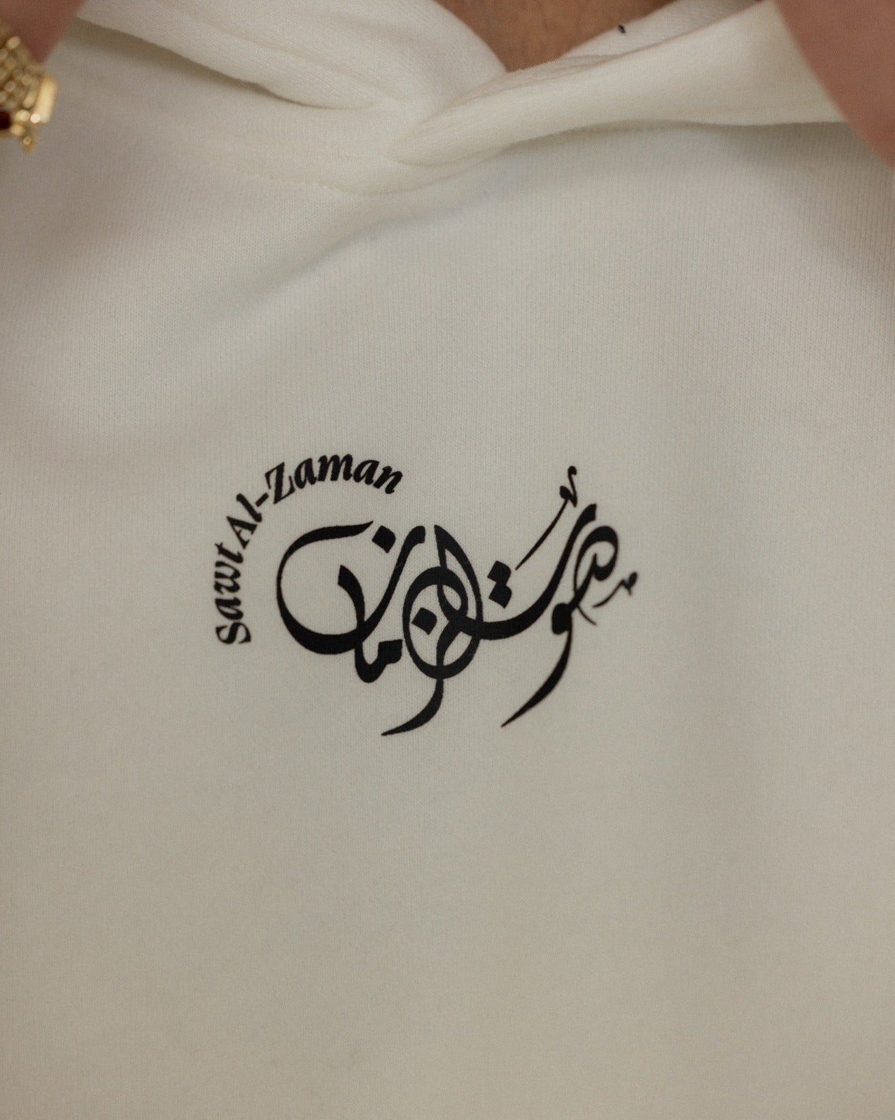 Close up of white Umm Kulthum hoodie featuring black Arabic calligraphy logo by Sawt Al-Zaman, printed on premium cotton fabric.