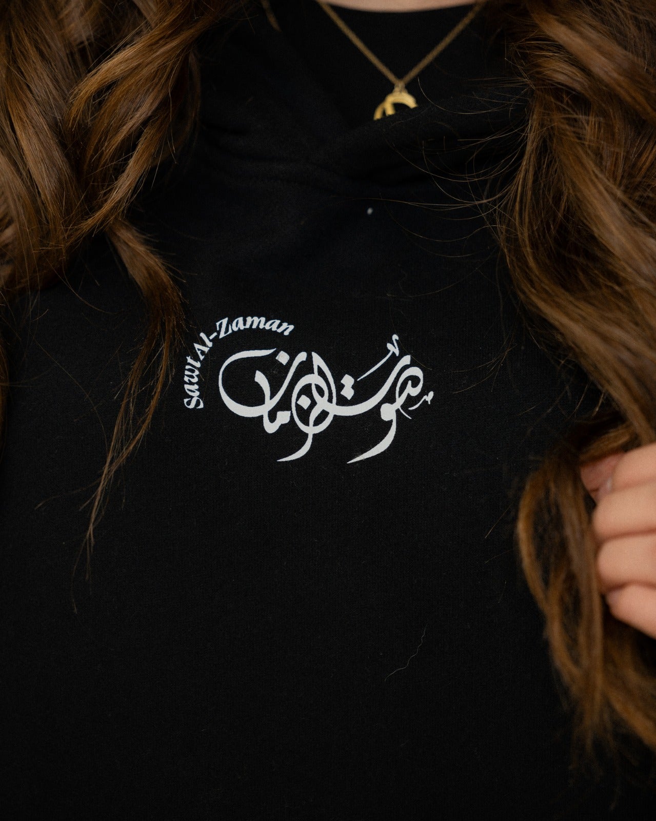 Close-up of black Umm Kulthum hoodie featuring white Arabic calligraphy logo by Sawt Al-Zaman